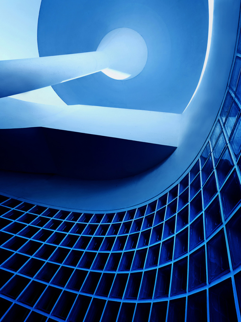Blaue Architekturaufnahme mit geschwungenen Formen und Glasbausteinen
